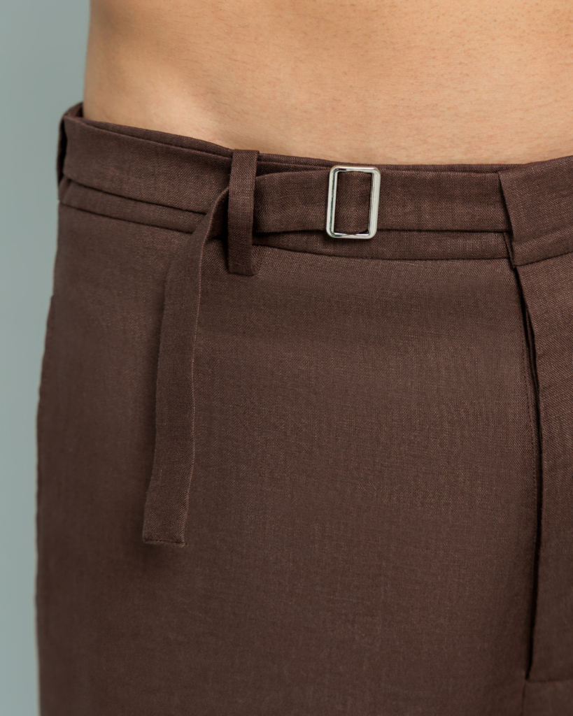 Close up of the natural shell button and metal buckle waist closure on 20Two Elemental ROOT TROUSER, Desert Dusk brown linen