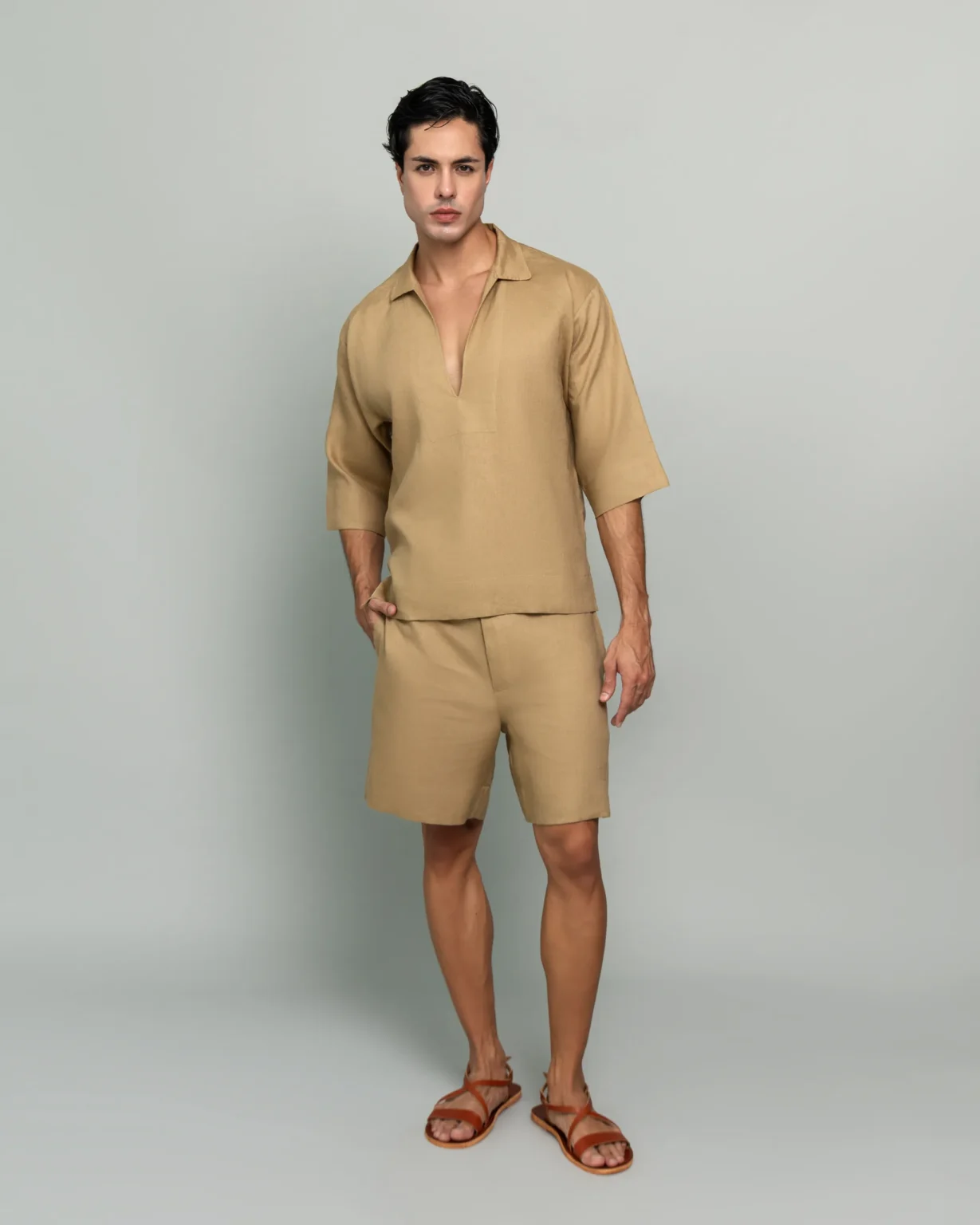 Man wearing 20Two Elemental's GHAF grain-top and drift short set in desert tan, front view, calm studio atmosphere