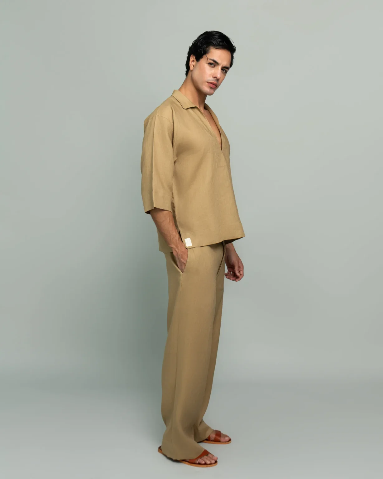 Side view of a man wearing 20Two Elemental's GHAF grain-top and rooted trouser set in desert tan