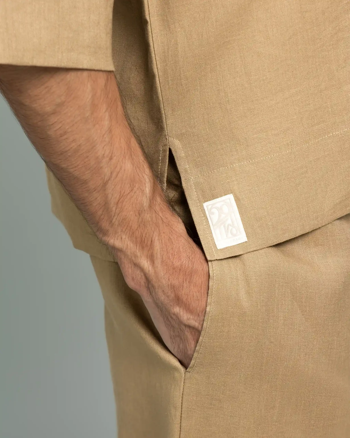 Close-up of the pocket and brand label detail on 20Two Elemental's GHAF grain-top and rooted trouser set in desert tan