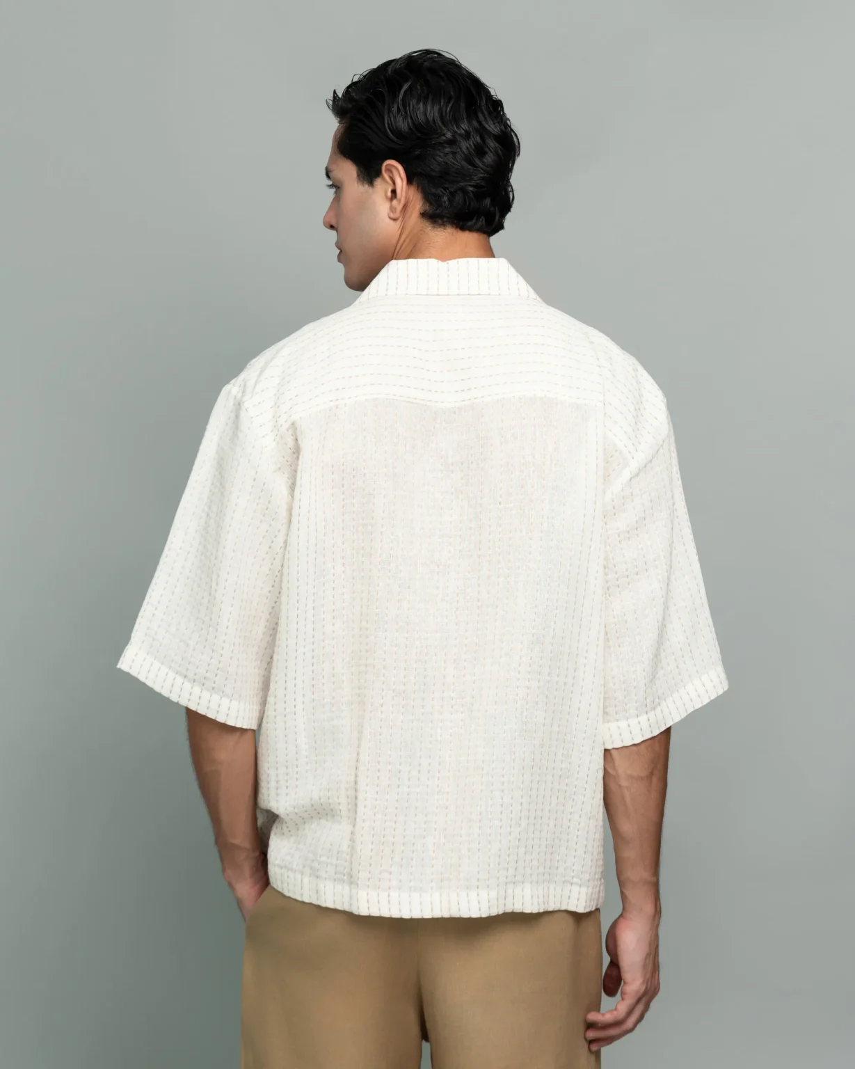 Back view of a man wearing 20Two Elemental's GHAF ivory over-shirt, medium shot