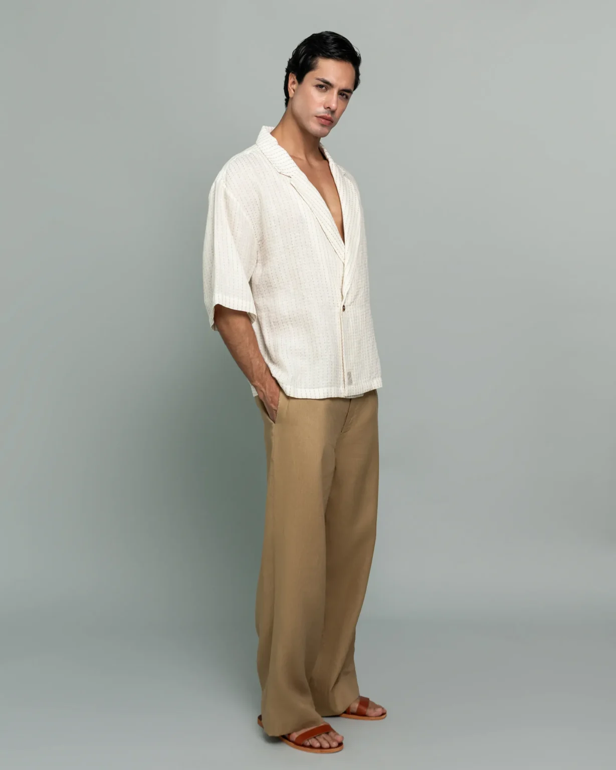 Man wearing 20Two Elemental's GHAF ivory over-shirt in a subtle stripe weave with a desert tan rooted trouser, front view, alternate pose