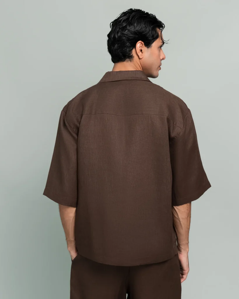 Back view of a man wearing 20Two Elemental's GHAF over-shirt and drift short set in brown, wrap-front shawl collar jacket