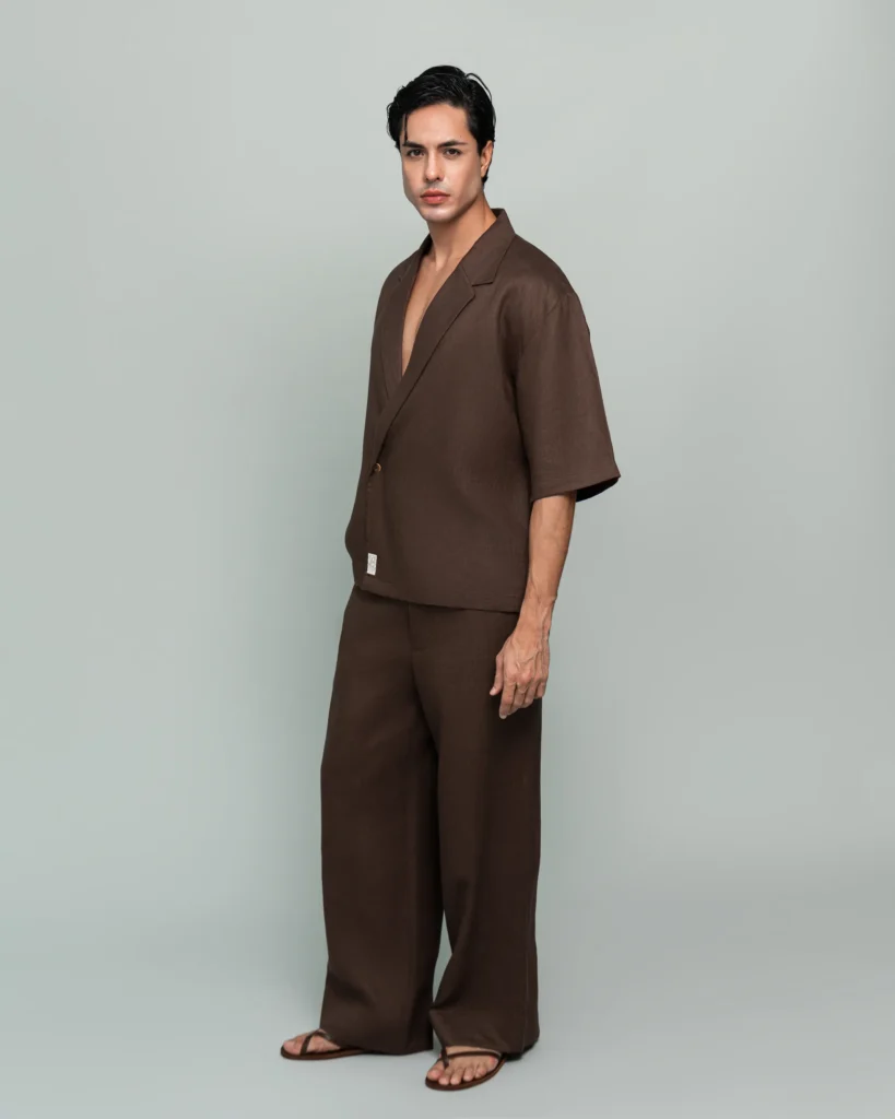 Man wearing 20Two Elemental's GHAF over-shirt and rooted trouser in brown, wrap-front shawl collar jacket, front view, calm studio atmosphere
