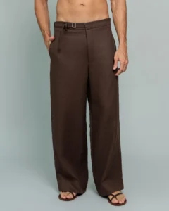 Man wearing 20Two Elemental's GHAF rooted trouser in brown, wide-leg silhouette with a self-tie belted waist, shirtless, standing against a soft sage studio backdrop