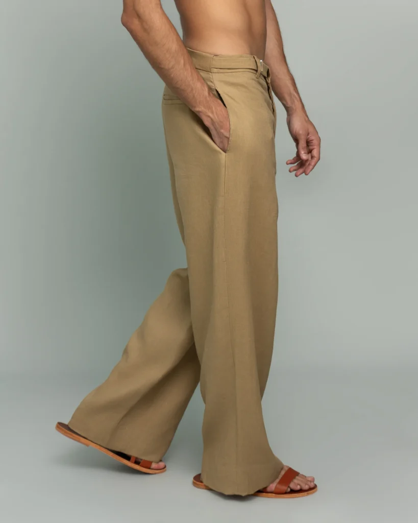 Side view of a man walking in 20Two Elemental's GHAF rooted trouser in desert tan, wide-leg silhouette